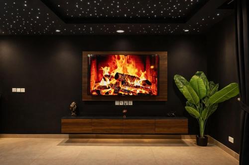 a living room with a fire on the wall at Gold Crest Signature Boutique Apartments With City Views -DHA PHASE 4 LAHORE in Lahore