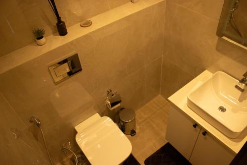 a bathroom with a white toilet and a sink at Sky View Condo at Solaris in Christiansborg