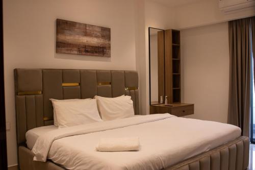a bedroom with a large bed with white sheets at Sky View Condo at Solaris in Christiansborg