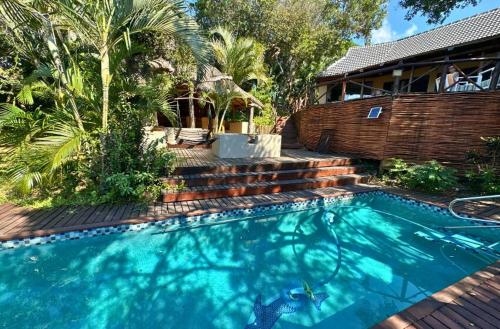 a swimming pool in front of a house at Baleia Azul 24 in Ponta Mamoli