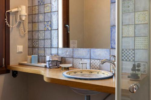 a bathroom with a counter with a sink and a shower at Kalderimi Country House in Mouresi