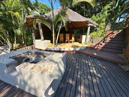 a resort with a hot tub on a wooden deck at Baleia Azul 24 in Ponta Mamoli