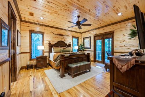 a bedroom with a desk and a bed in a log cabin at Call It A Day Luxury Cabin in Stephens Gap