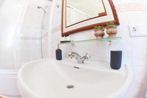 a bathroom with a sink and a mirror and a toilet at Verde Mar, vive el oceano en primera linea in La Santa