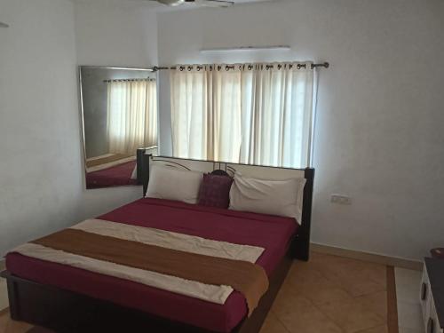 a bedroom with a large bed with a mirror at Gurudeva stay inn in Covelong