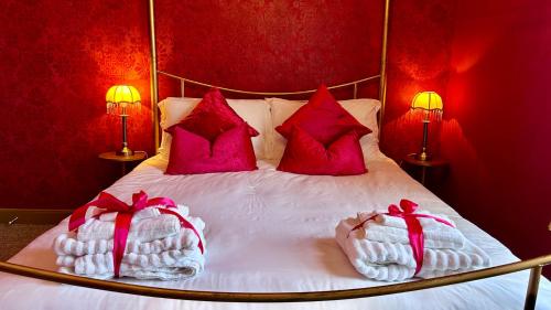 a bed with red walls and two pillows on it at Downton I in Alnwick