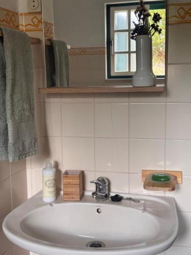 a white sink in a bathroom with a window at Monte Santo in Montargil