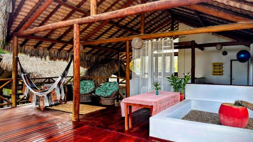 a porch with a hammock and a table and chairs at Serena Pousada - Icaraí de Amontada in Icaraí