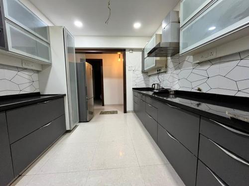 a kitchen with black and white counters and appliances at Spacious 4 BHK flat- 4 Beds in Indore