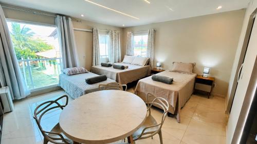 a room with two beds and a table and chairs at Blessed House Atins in Atins