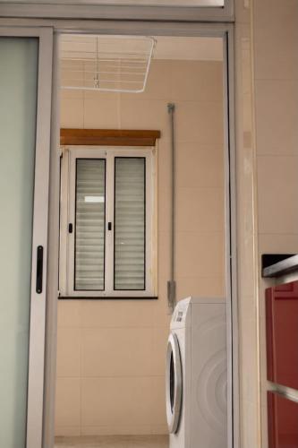 a washing machine in a room with a window at Casa do Pirata by GuestPro in Matosinhos