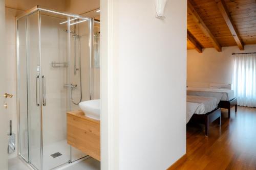 a bathroom with a shower and a sink and a bed at Agriturismo Costa Arènte in Grezzana