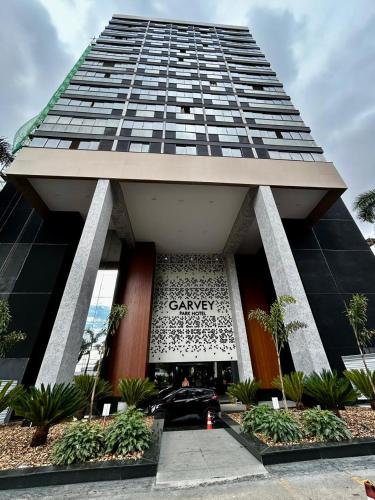 a car parked in front of a tall building at Flats em Brasília no Garvey Park Hotel in Brasília