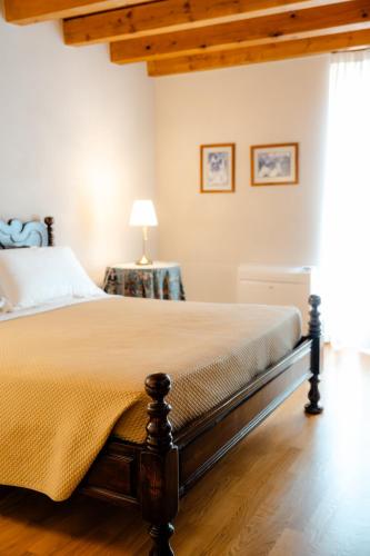 a bedroom with a bed and a lamp on a wooden floor at Agriturismo Costa Arènte in Grezzana