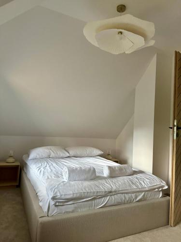 a bedroom with a white bed with a ceiling fan at Hi Wisła in Wisła