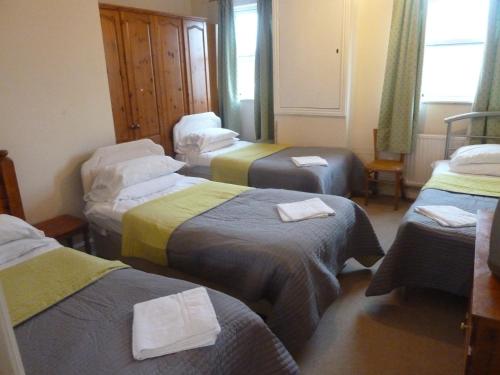 a room with three beds with towels on them at The Rathmore in Cambridge