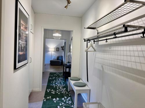 a hallway with a table and a rug at Prinshöjden Apartments - Katrineholm Central in Katrineholm