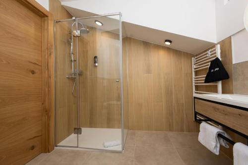 a shower with a glass door in a bathroom at Apartmenthotel Rosentaler Hof Quartier2 in Pirk