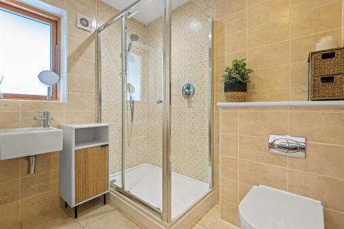 a bathroom with a shower and a toilet and a sink at House 29 in Looe