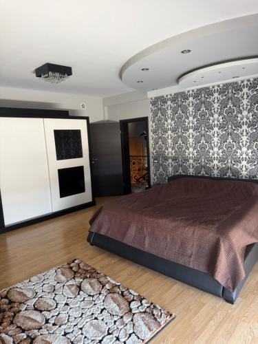 a bedroom with a large bed and a rug at Prishtina Luxury House in Laplje Selo