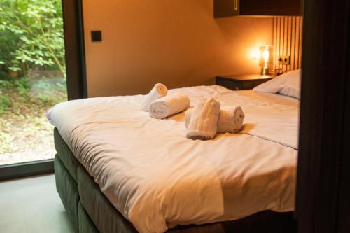 a bedroom with a bed with towels on it at Vakantiepark Samoza in Vierhouten