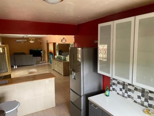 a kitchen with a refrigerator and a living room at Samba immo chez Mbaye in Fatick