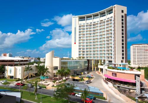 a large white building in a city with a street at Krystal Urban Cancun & Beach Club in Cancún