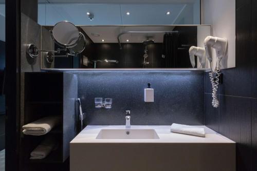 a bathroom with a sink and a mirror at Scandic Tampere Hämeenpuisto in Tampere