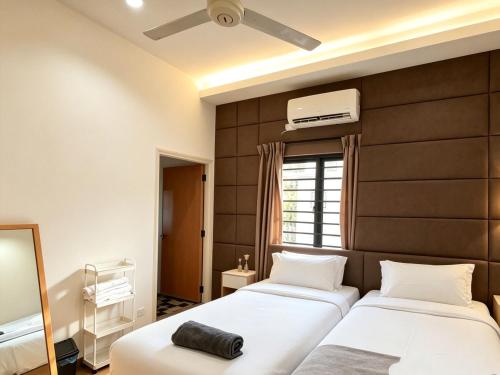 two beds in a bedroom with a large wall at MELAKA BEACH VILLA ( A TYPE ) in Kelebang Besar