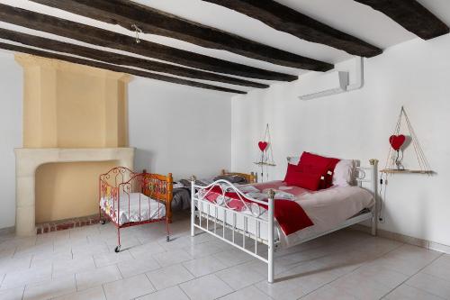 a bedroom with a bed with red pillows at Logis des gourmets in Hommes
