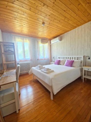 a bedroom with a large white bed and a wooden ceiling at Locanda Livenza camere in Motta di Livenza