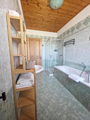 a bathroom with a large tub and a wooden ceiling at Locanda Livenza camere in Motta di Livenza