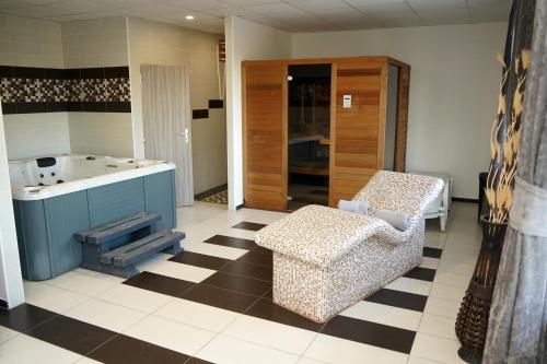 a bathroom with a checkered floor and a chair and a sink at Panorama Motel -Wellness in Veľký Meder