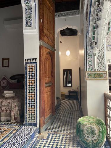 a room with a door and a room with a bed at Rooms in Dar Drouj, a special 14th century house Riad in Fez