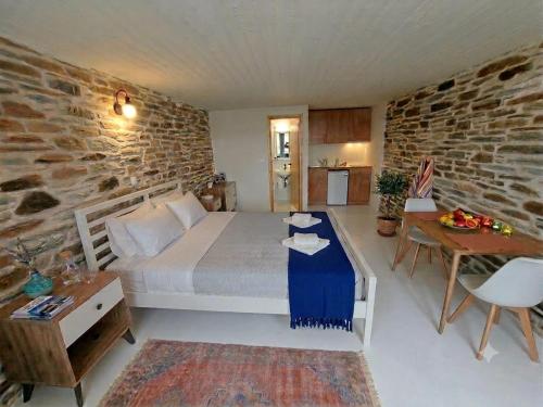 a bedroom with a bed and a stone wall at Stavros Bay in Tinos