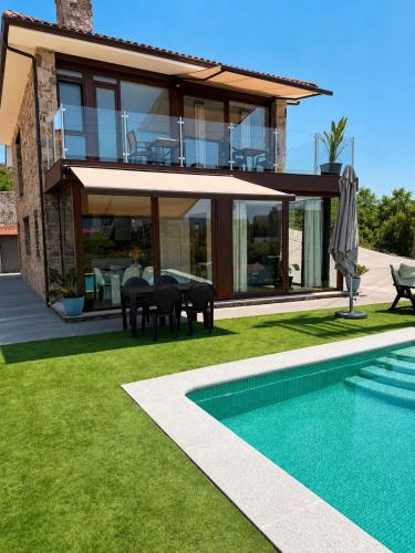 a villa with a swimming pool and a house at CESANTES VILLAGE e in Pontevedra