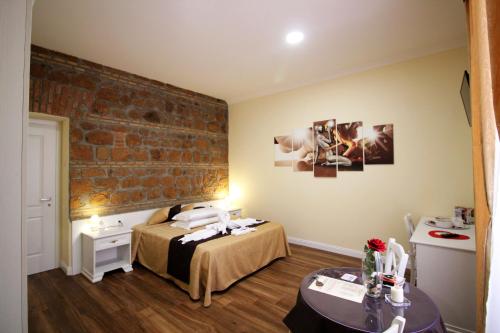 a room with a bed and a brick wall at Freedom Love B&B in Rome