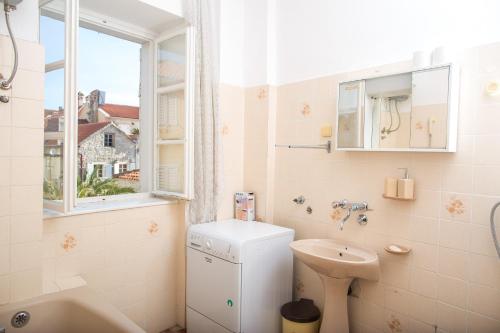 a bathroom with a sink and a toilet and a window at Apartments Old Town in Budva