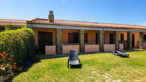 a building with a yard with benches in front of it at La Tonnara House in Stintino