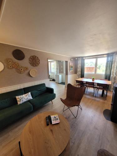 a living room with a green couch and a table at L'Annexe de Steph in Loulans-Verchamp