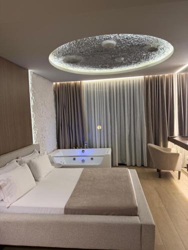 a bedroom with a large bed and a chandelier at Seamare Studio & Apartaments in Vlorë