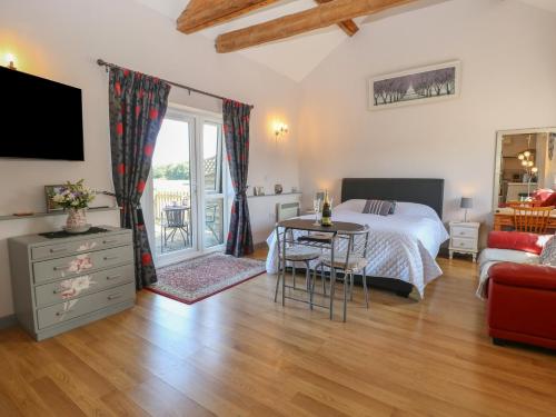 a bedroom with a bed and a table at Snowy Owl Barn in Shipdham