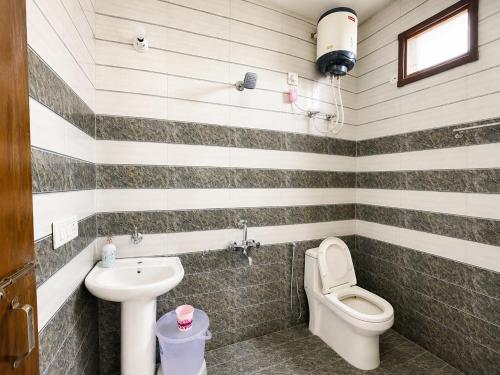a bathroom with a toilet and a sink at The Amber Retreat - Best Property In Mussoorie #Luxury Rooms #Balcony #Parking #Budget Friendly #Mountain View #Restaurant #Couple Friendly in Mussoorie