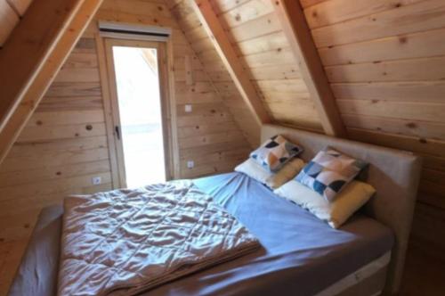 a bed in a room in a log cabin at Vlado Retreat in Banja Luka