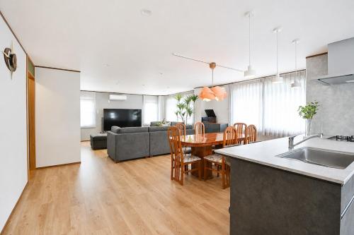 a kitchen and living room with a table and a couch at Tokyo Grand House in Akishima