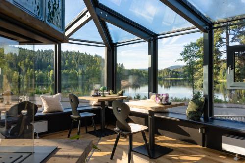 a room with large windows and tables and chairs at Köhlerei am See in Feldberg