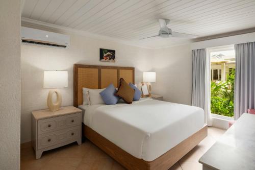 a bedroom with a large white bed and a window at Treasure Beach Art Hotel, An Autograph Collection All-Inclusive Resort in Saint James
