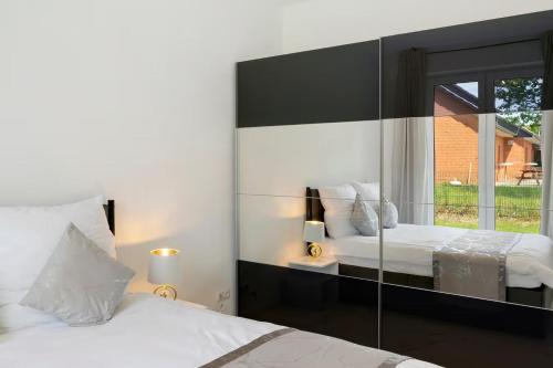 a bedroom with two beds and a large mirror at Gemütliche Wohnung mit Terrasse im Grünen in Bienenbüttel