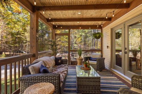 a screened in porch with furniture and a table at Luxury Retreat, Views, Near Whiteface, Lake Placid in Jay
