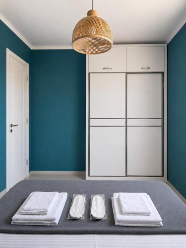 a room with a bed with blue walls and white cabinets at Aura House in Tsalka